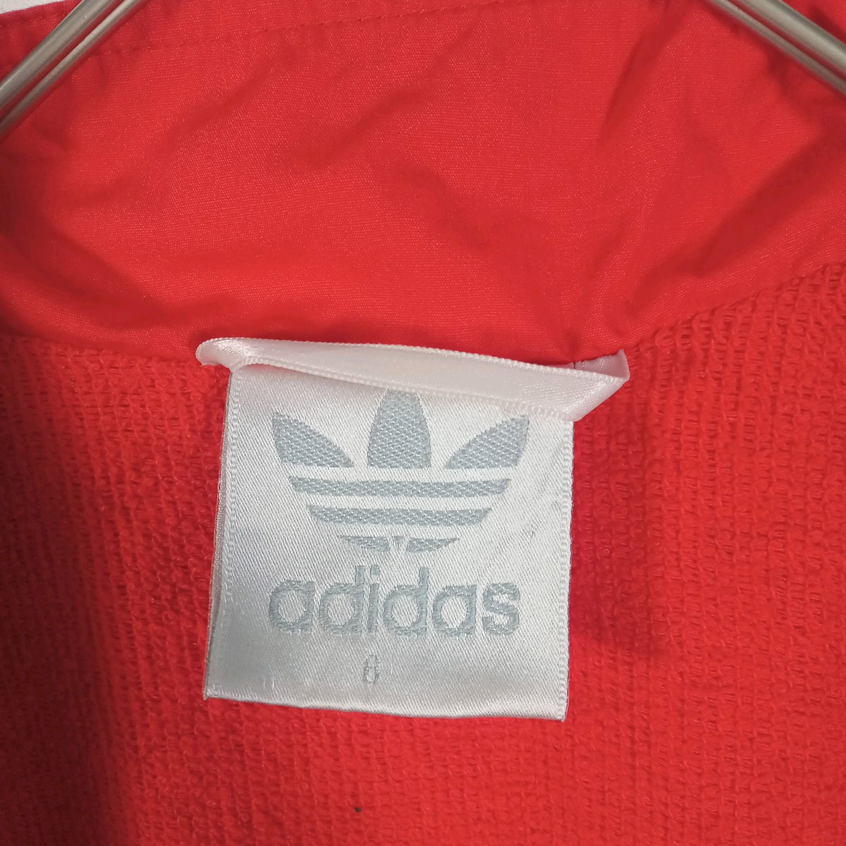 アディダスの首元の白いタグ。トレフォイルとadidasの文字