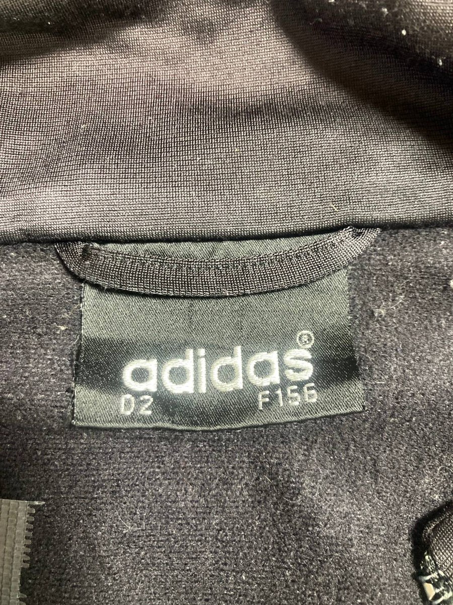 黒地に白で adidas の文字だけが入ったタグ。サイズ表記 D2・F156
