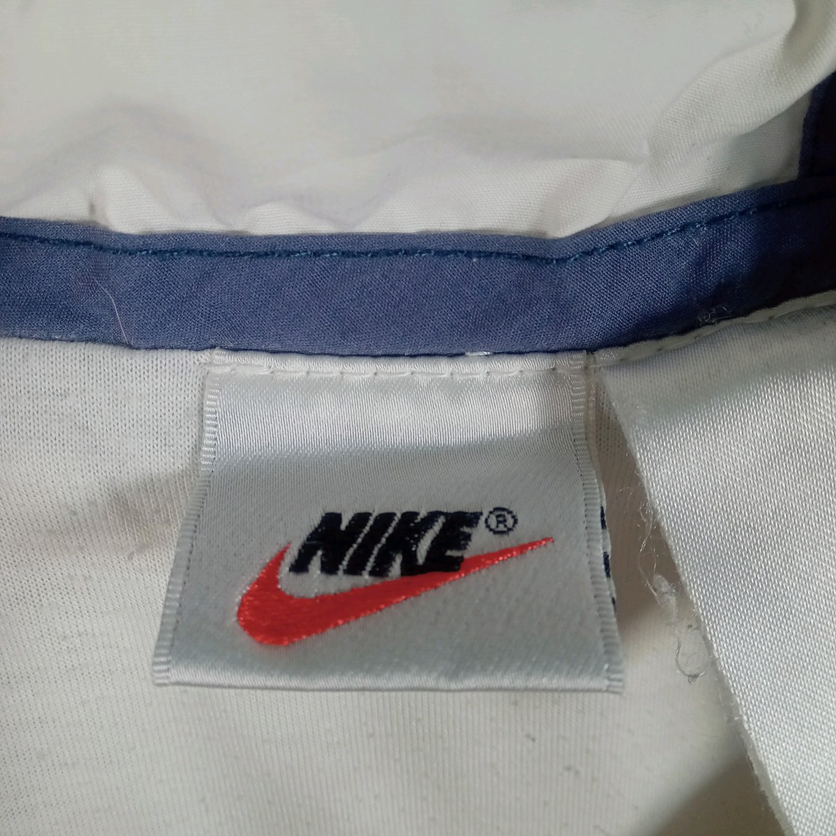 ナイキの首元のタグ。白地に黒のNIKEの文字と赤のスウッシュ